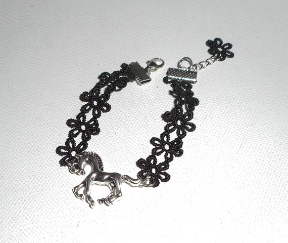 Original pulsera con caballo de metal plateado sobre encaje negro