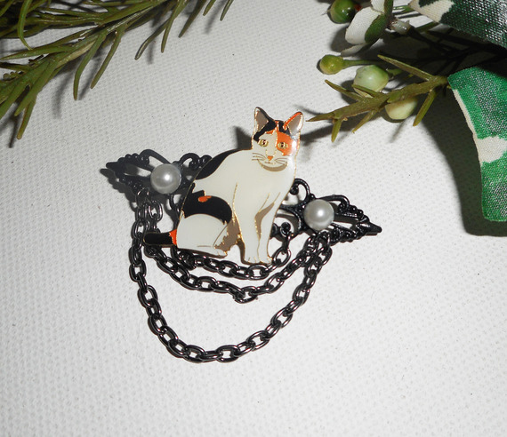 Broche de gato con perlas esmaltadas y cadena negra