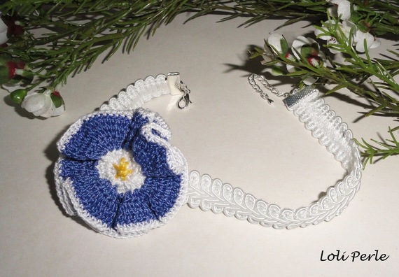 Collar de flores azules sobre trenza de fantasía blanca