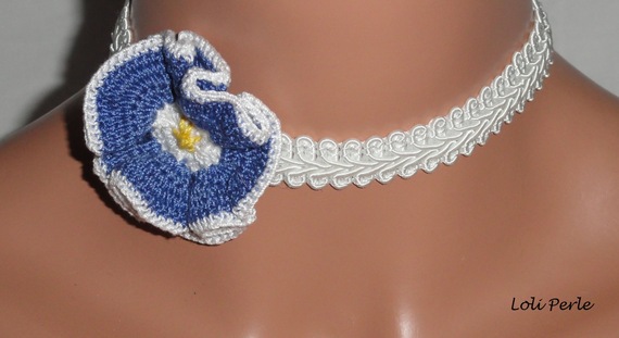 Collar de flores azules sobre trenza de fantasía blanca