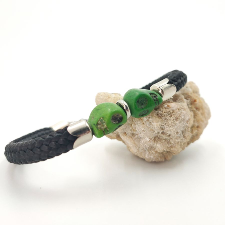 Pulsera doble de calavera y tibias cruzadas con piedras verdes sobre cuerda negra