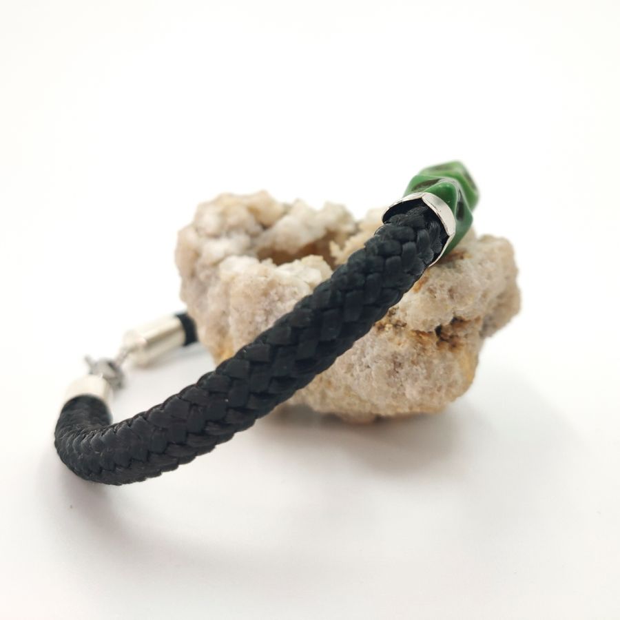 Pulsera doble de calavera y tibias cruzadas con piedras verdes sobre cuerda negra